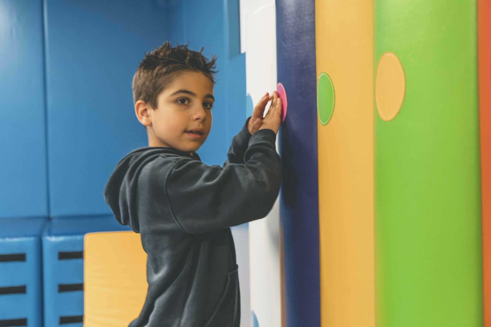 Student exploring tactile wall in sensory room